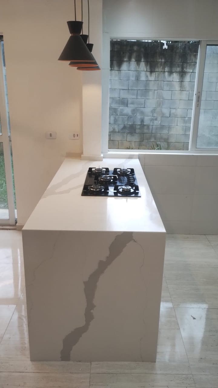 Ilha de cozinha Peça em mármore com cooktop.