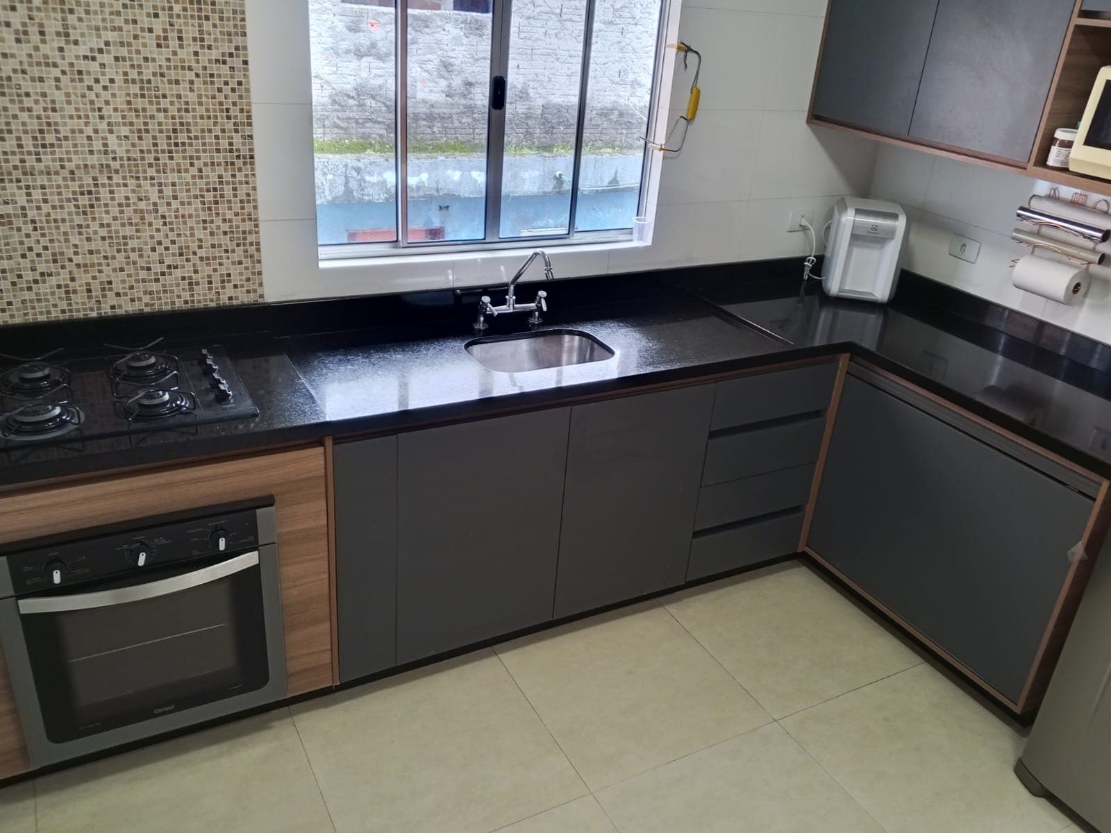 Cozinha sob medida Bancada em L com cuba inox.