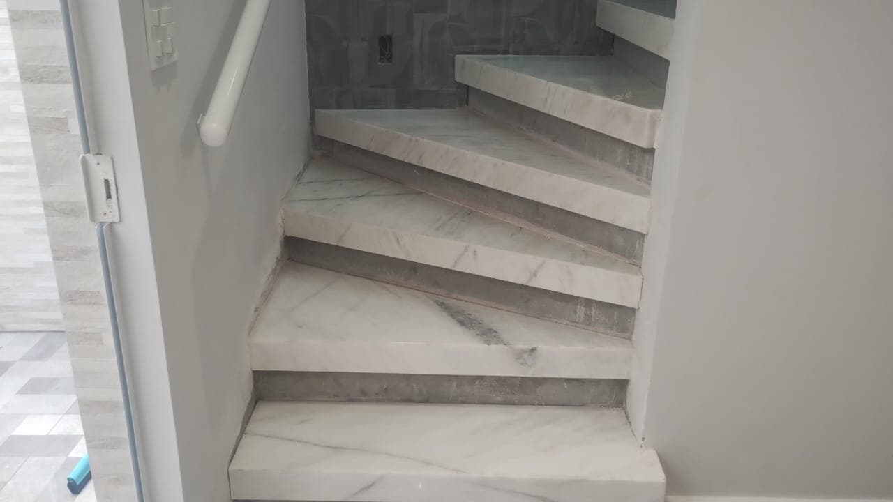 Escada em mármore branco Degraus com acabamento limpo e elegante.